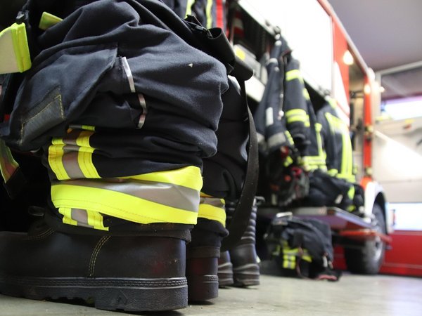 Feuerwehrausrüstung liegt neben einem Feuerwehrfahrzeug