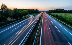 Bild einer Autobahn mit Scheinwerfern und Rücklichtern von Fahrzeugen