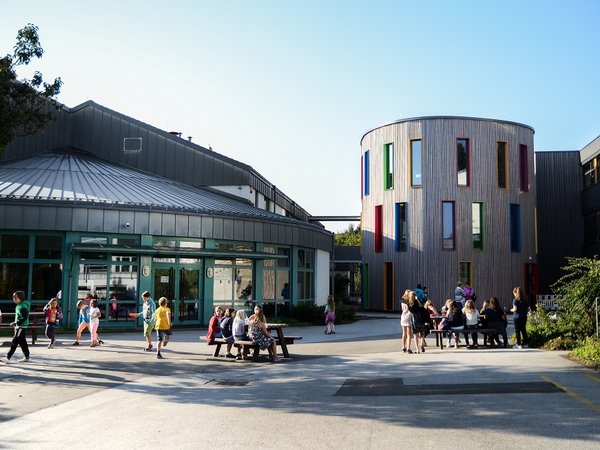 Außenansicht Primusschule mit Kindern auf dem Schulhof