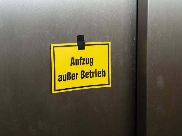 Gelber Zettel mit der Aufschrift , Aufzug außer Betrieb , an der Fahrstuhltür
