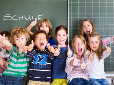Schulkinder vor einer Tafel im Klassenraum