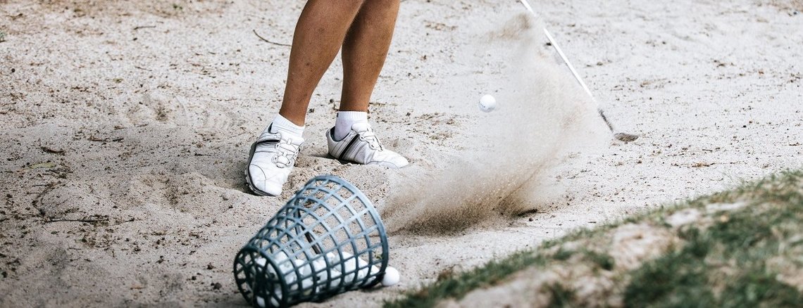 Abschlag auf dem Sand am Golfplatz