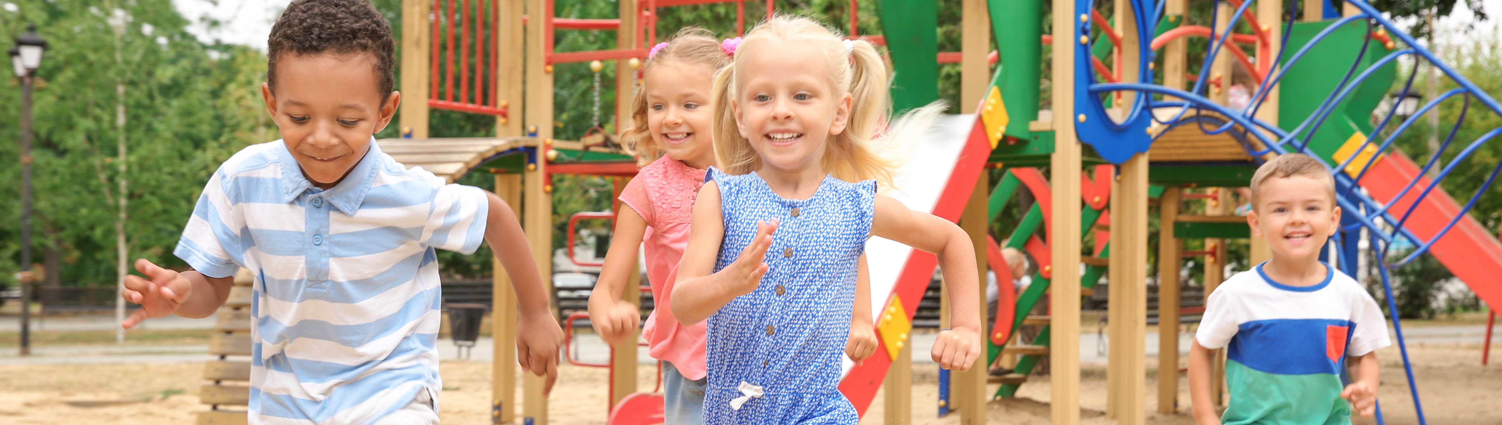 Kinder auf einem Spielplatz laufen der Kamera entgegen