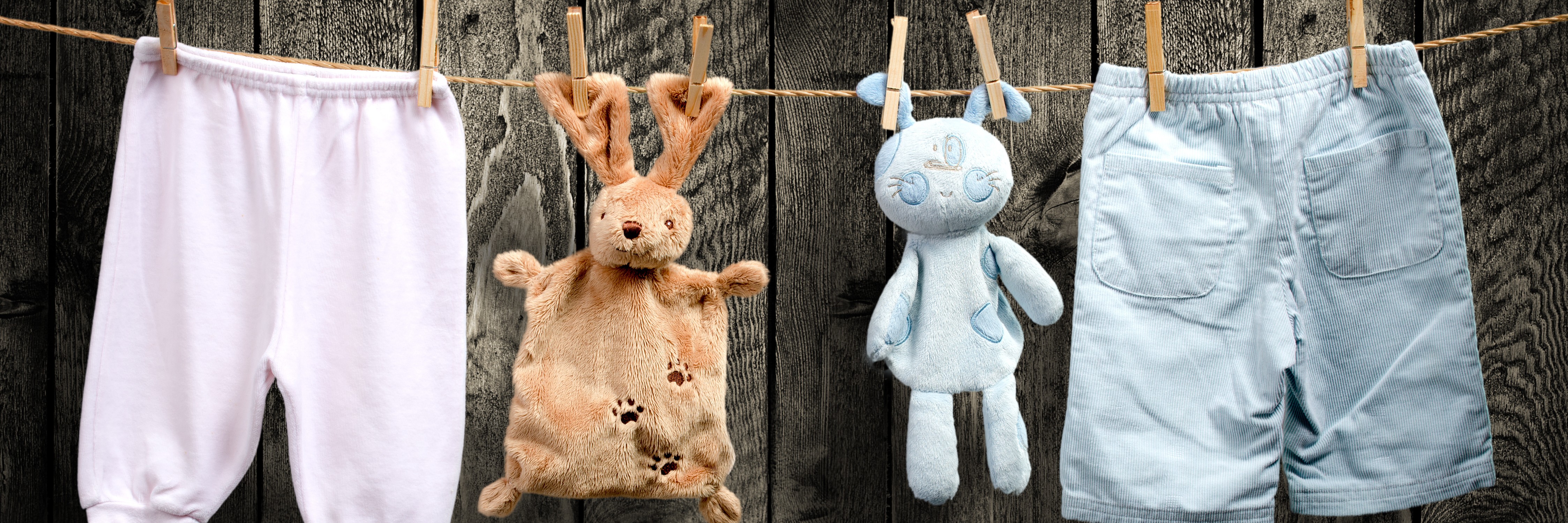Wäscheleine mit Kinderkleidung und Kuscheltieren
