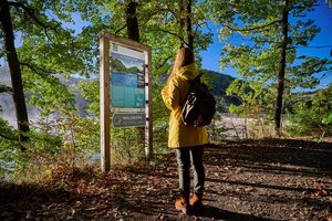 Wandertafel mit einer Wanderin auf einem Wanderweg