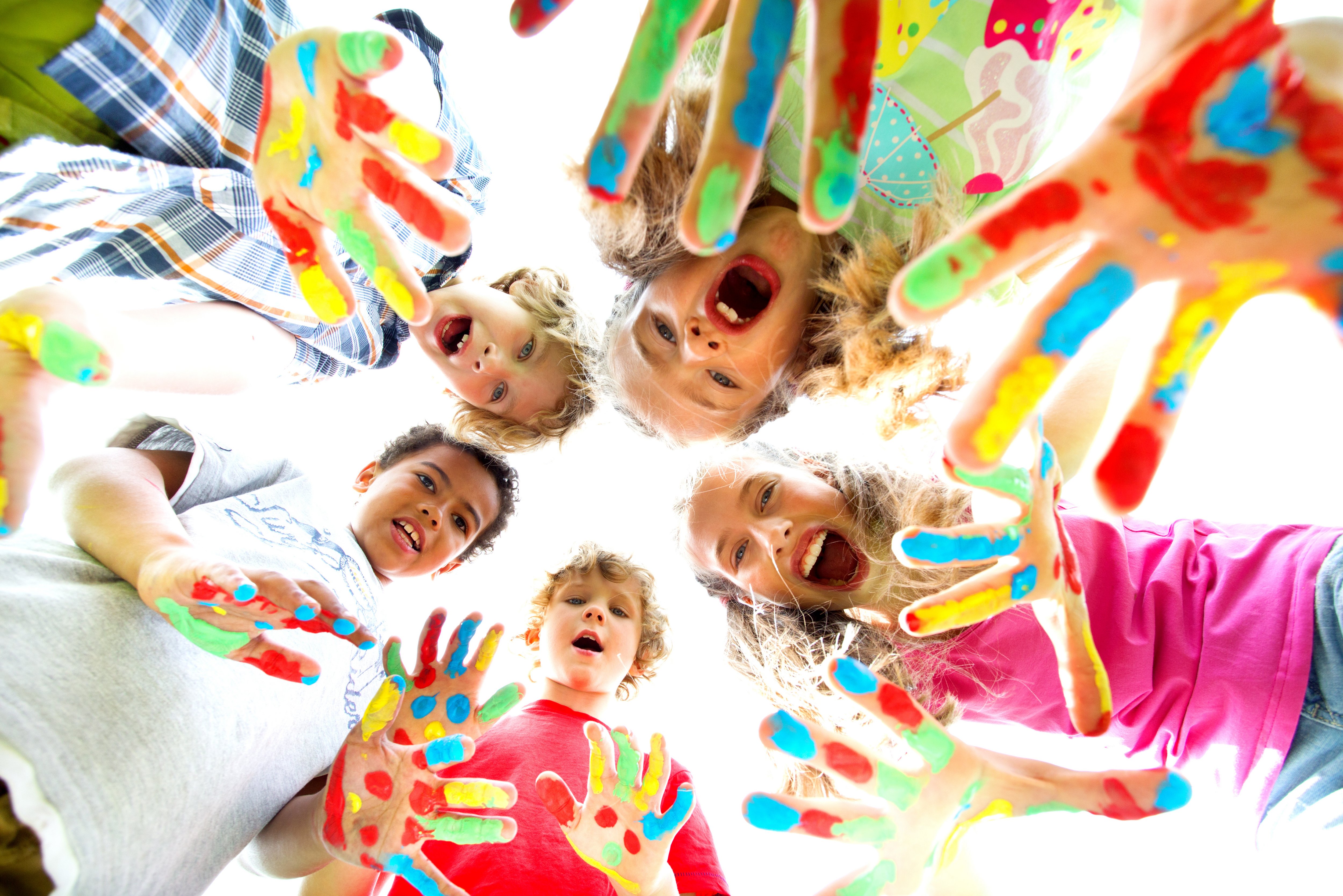 smiling kids with colourfull hands Lachende Kinder mit bemalten Händen