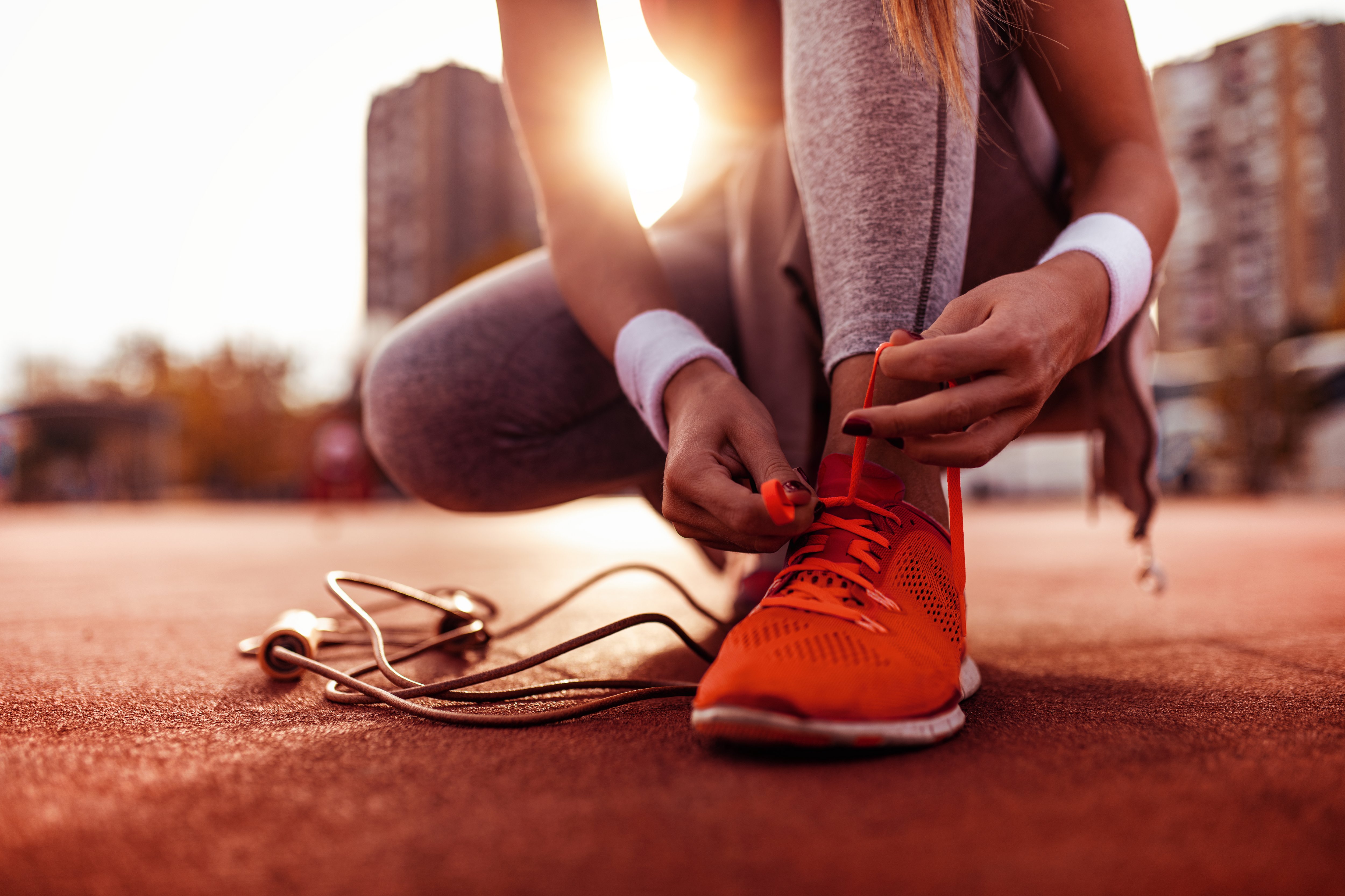 Läuferin Schnürt sich Schnürsenkel zu Läuferin Schnürt sich Schnürsenkel zu um joggen zu gehen