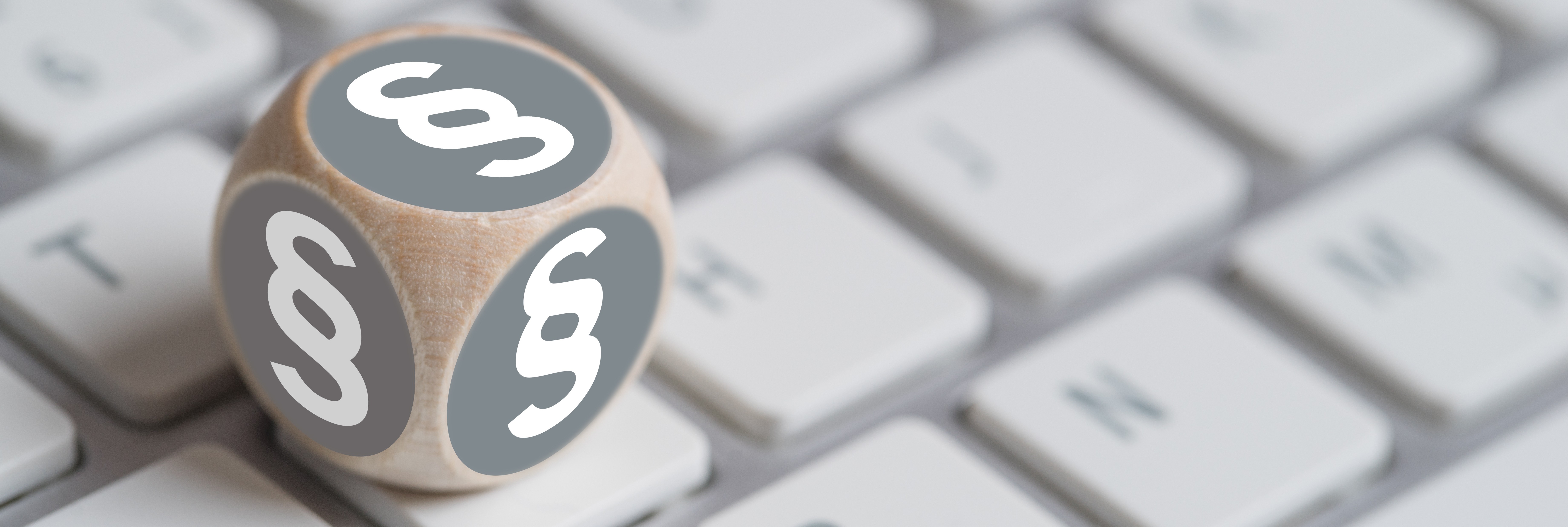 Würfel mit Paragraph Symbolen auf einer Tastatur