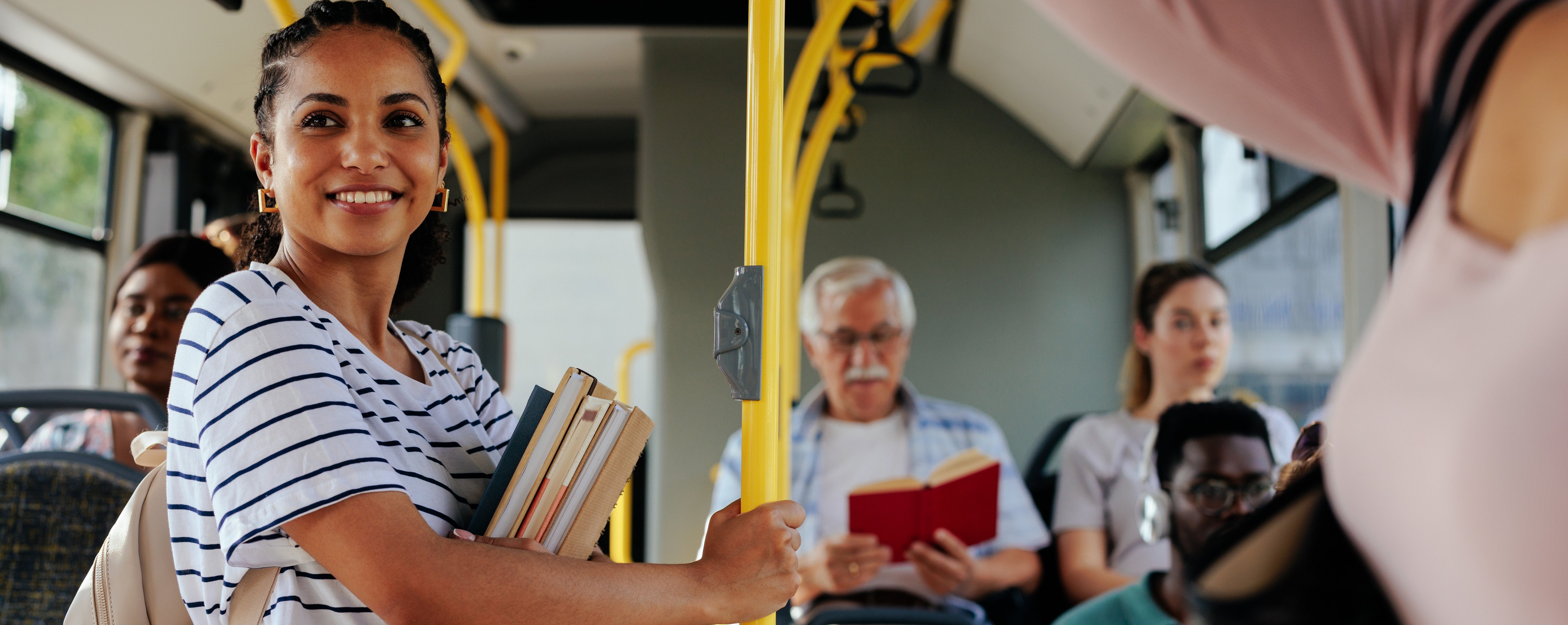 lachende Frau steht in einem vollen Bus